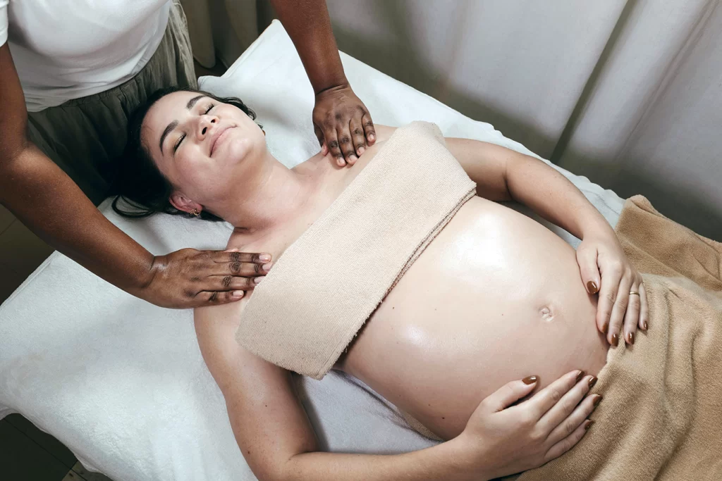 Pregnant woman getting a massage on her shoulders.
